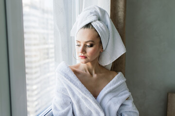 Beautiful young healthy woman relaxing in a robe, hotes, room, spa salon