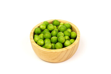 Pea eggplant or turkey berry in wooden bowl isolated on white background. Solanum torvum is ingredients for cooking Thai food. 