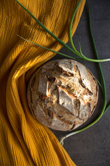 Crusty bread on a yellow kitchen towel. Top view photo of fresh baked sourdough bread. 