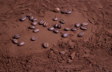 Close-up of scattered coffee beans on ground roasted coffee. Food background