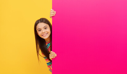 happy teenager girl behind pink paper sheet with empty place for copy space, advertising