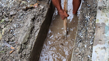 Selective focus image, workers clearing sewers from clogged trash