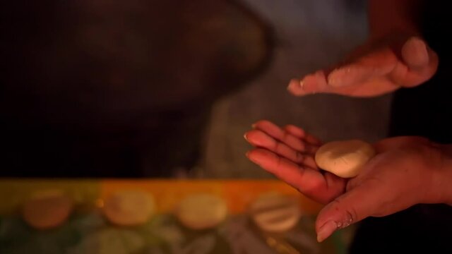 Hands kneading corn dough above a row of small sopes on table