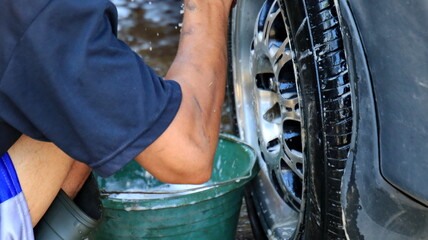 worker car cleaning, spraying and wiping, at his workplace