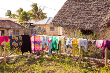 street in african village. Wet clothes clothes hanging out on wooden fence, Tropical climate. Zanzibar, Tanzania