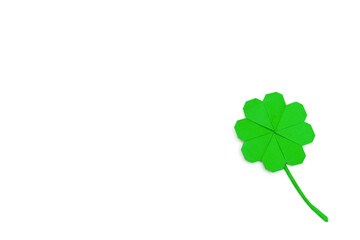 A leaf of clover, folded in the origami technique of green paper on a white background.Concept of St.Patrick's Day.Copy space,top view, flat lay.