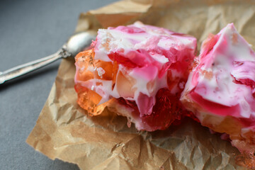 Fruit milk colorful jelly cake on parchment paper.
Multicolored gelatin dessert