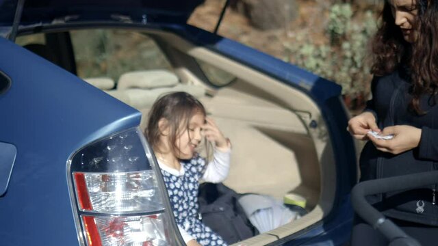 Happy little girl and her mother in the back of a vehicle