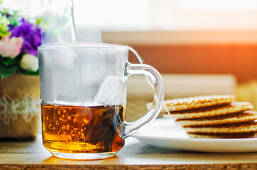 Put the tea bag in a transparent glass in a cup and pour boiling water over it.