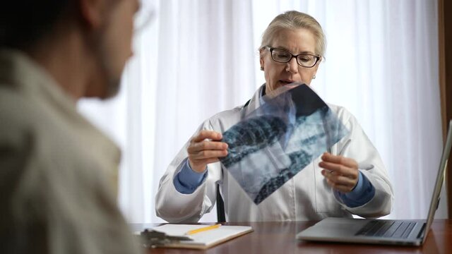 Doctor is shows X-ray images to patient. Slow motion concept of doctor discuss personal healthcare.