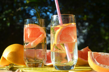 Girl cooking healthy detox smoothie with fresh fruits and green rosemary grapefruit water. Lifestyle detox concept