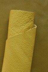 Yellow genuine leather roll.real leather . Leather in rolls on a dark beige  surface.Hobby and...
