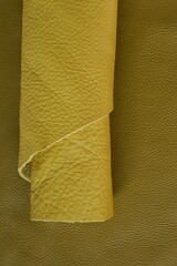 Yellow genuine leather roll.real leather . Leather in rolls on a dark beige leather surface.Hobby and craft material. leather texture.Material for shoes and accessories	