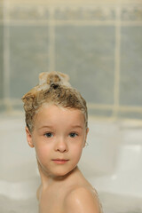 portrait of a little girl in a bath with lathered hair