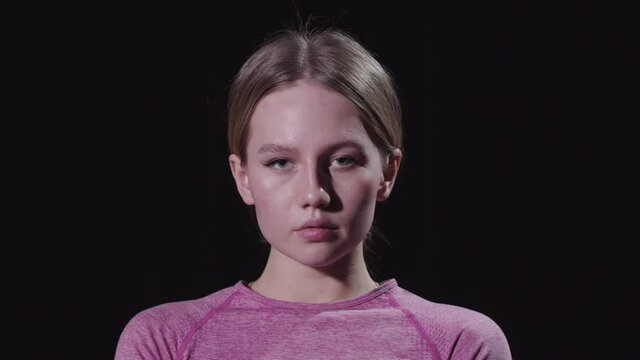 Young Beautiful Woman Gymnast Put Her Hair In A Bun And Looking In The Camera