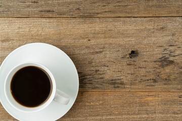 A cup of coffee on a shabby wooden board background. Flat lay. Copy space.