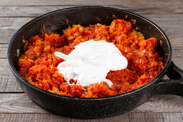 Sour cream in a frying pan on a table. Step by step. Step 3