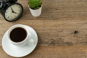 A cup of coffee on a shabby wooden board background.