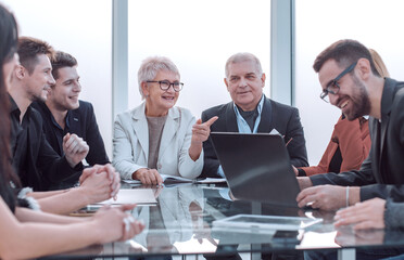 Businesswoman leads meeting around table