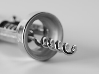 Corkscrew for opening wine bottles on an isolated white background close-up, selective sharpness