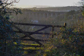 Old wooden farm gate viaduct in background