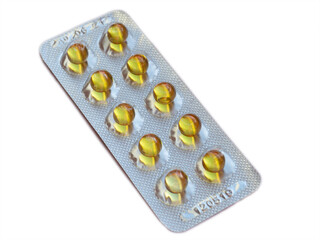 Full blister pack of vitamins on an isolated white background. Round yellow tablets in a blister pack. Complete package of vitamin A and E.