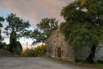 Landscape view of Sao Pedro chapel with trees and boulders in Monsanto, Portugal