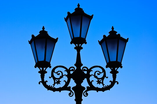 Street lantern lamps silhouette on blue sky background