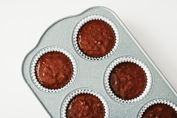 Chocolate muffin or cupcake batter in a pan ready to bake, homemade comfort food recipe