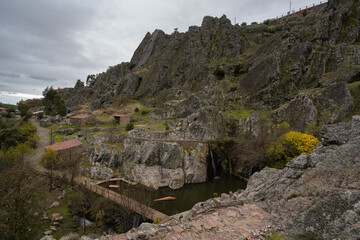 Penha Garcia historic village waterfall and Pego river beach on a cloudy day, in Portugal