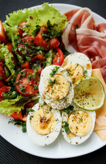 Boiled eggs, bacon, avocado and tomatoes and lettuce salad. Healthy breakfast. 