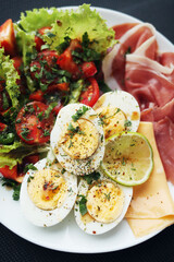 Boiled eggs, bacon, avocado and tomatoes and lettuce salad. Healthy breakfast. 