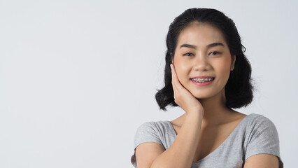 Dental brace teen girl smiling looking on a camera. white teeth with blue braces. Dental care. Asian woman smile with orthodontic accessories. Cosmetic dentistry, orthodontics treatment. Oral braces.
