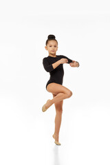 gymnast girl standing in ballet pose on white background in studio