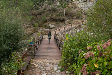 Obraz premium Woman walking on a bridge in Penha Garcia historic village Pego river beach, in Portugal