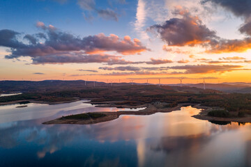 Drone aerial view of a lake reservoir of a dam with perfect reflection on the water of the sunset in Sabugal, Portugal