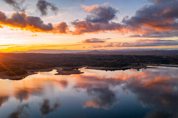 Fototapeta na wymiar Drone aerial view of a lake reservoir of a dam with perfect reflection on the water of the sunset in Sabugal, Portugal