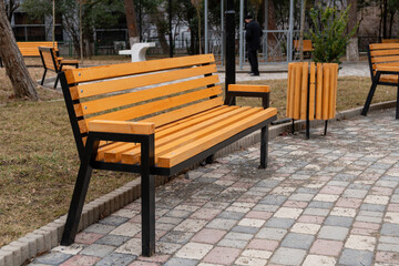 Obraz premium Wooden bench in the city park, place for relaxation