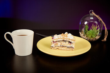 Piece of homemade cake with fruits on the orange plate with cup. Morning. Studio light