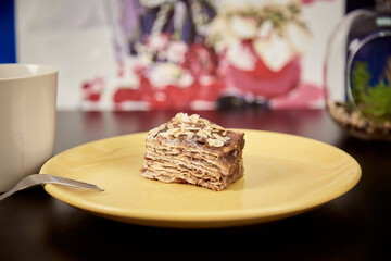 Piece of honey chocolate cake with walnuts and orange peel on the orange plate.