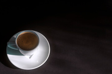 Morning coffee concept: white cup of turkish coffee on dark background