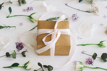 Happy mothers day and womens day concept. Craft present with ribbon and modern floral composition