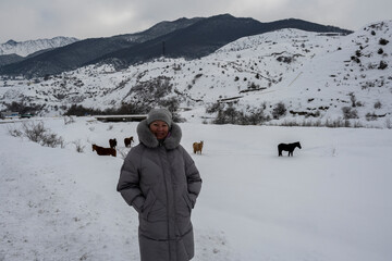 Fototapeta na wymiar woman in a gray jacket travels in the winter in the Caucasus mountains 