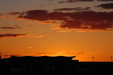 Airport terminal silhouette on sunset sky background