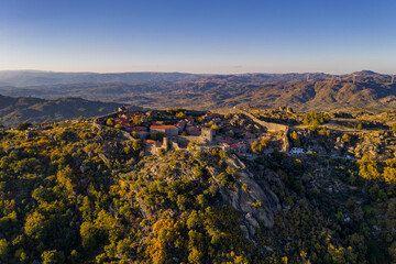 Drone aerial panorama of historic village of Sortelha with castle and with turbines on natural landscape, in Portugal