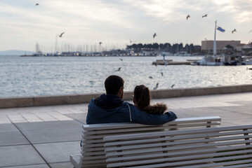 A couple in love on a bench by the sea,view from behind.