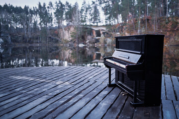 Music and nature. Old black piano near forest lake. © Loginova