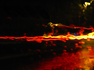 Light trace of night city traffic in the rain abstract background