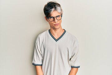 Young hispanic man wearing casual clothes and glasses skeptic and nervous, frowning upset because...
