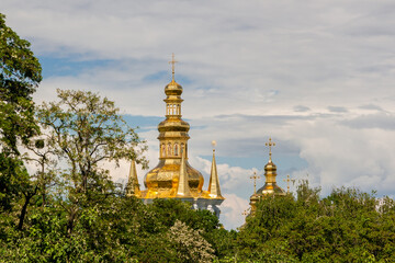 Fototapeta na wymiar Church domes make their way through trees